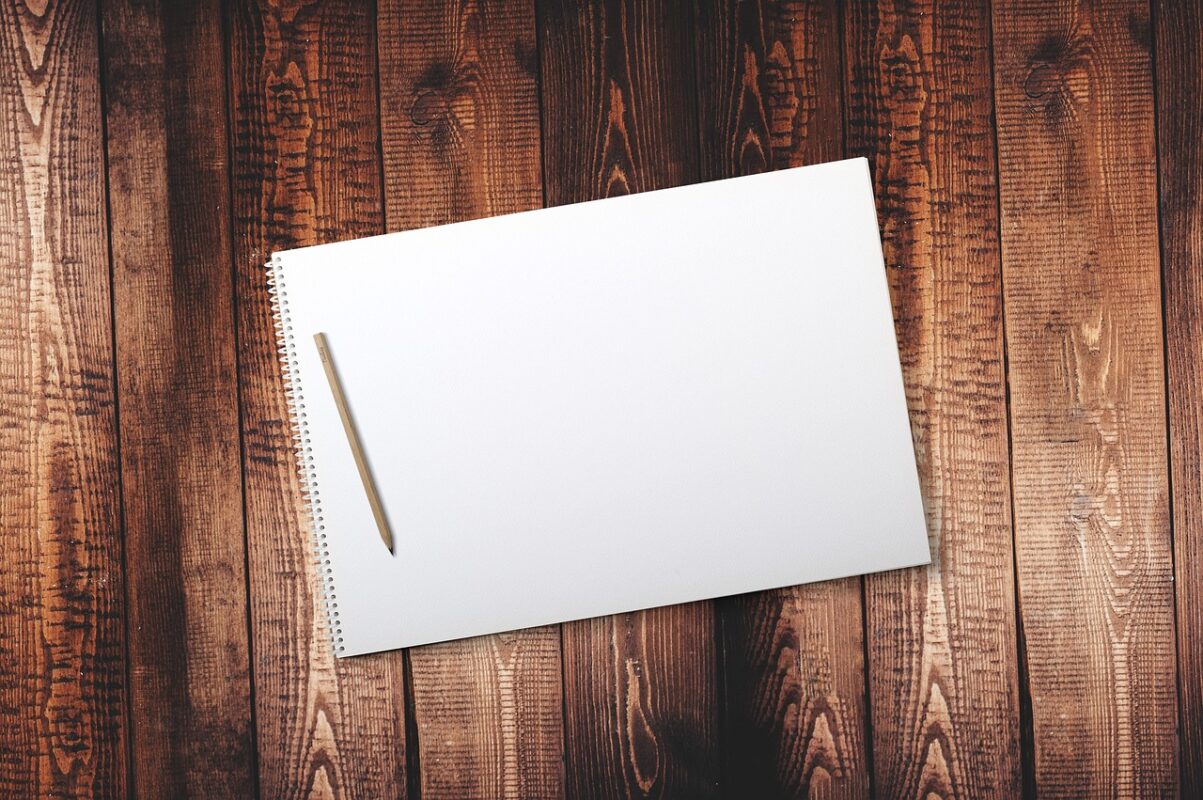 A drawing desk with sketchbook and pencils