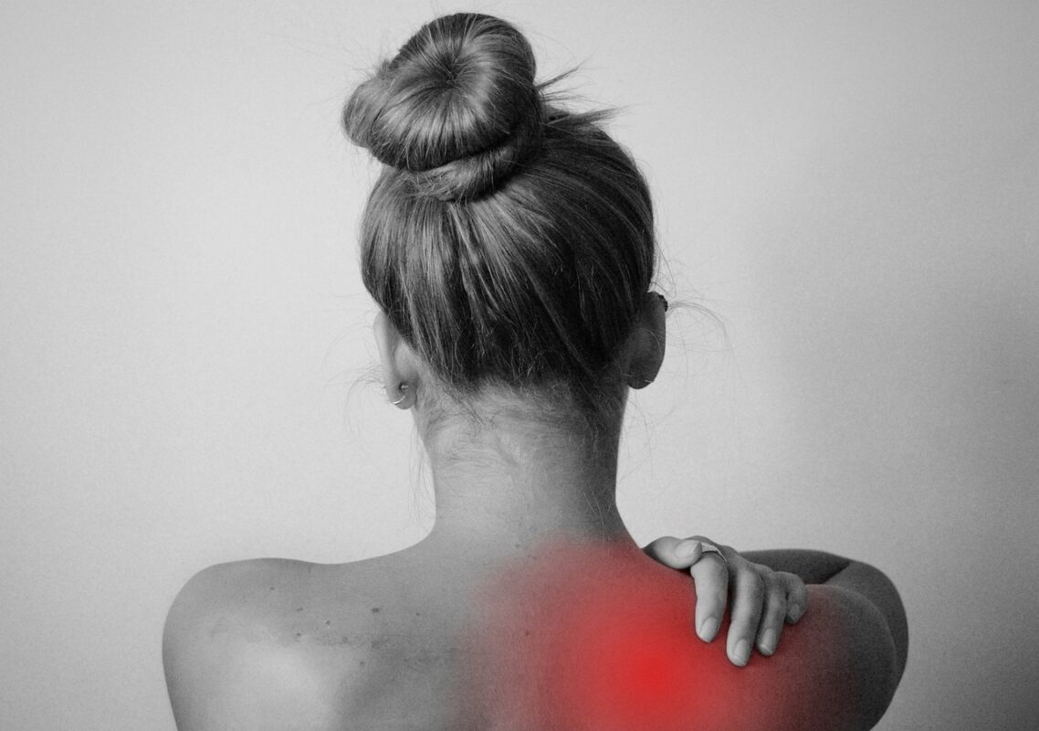 Person using a neck and shoulder massager at a desk