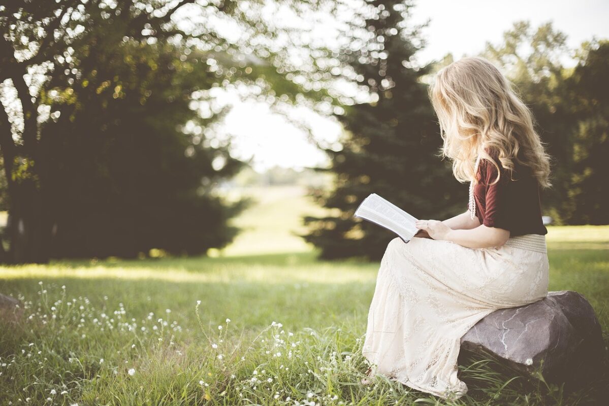 Person reading a book with notes in the margin